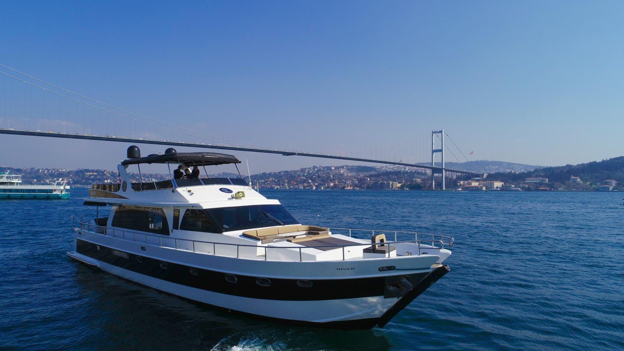 The luxury yacht cruising the Bosphorus beneath the Bosphorus Bridge
