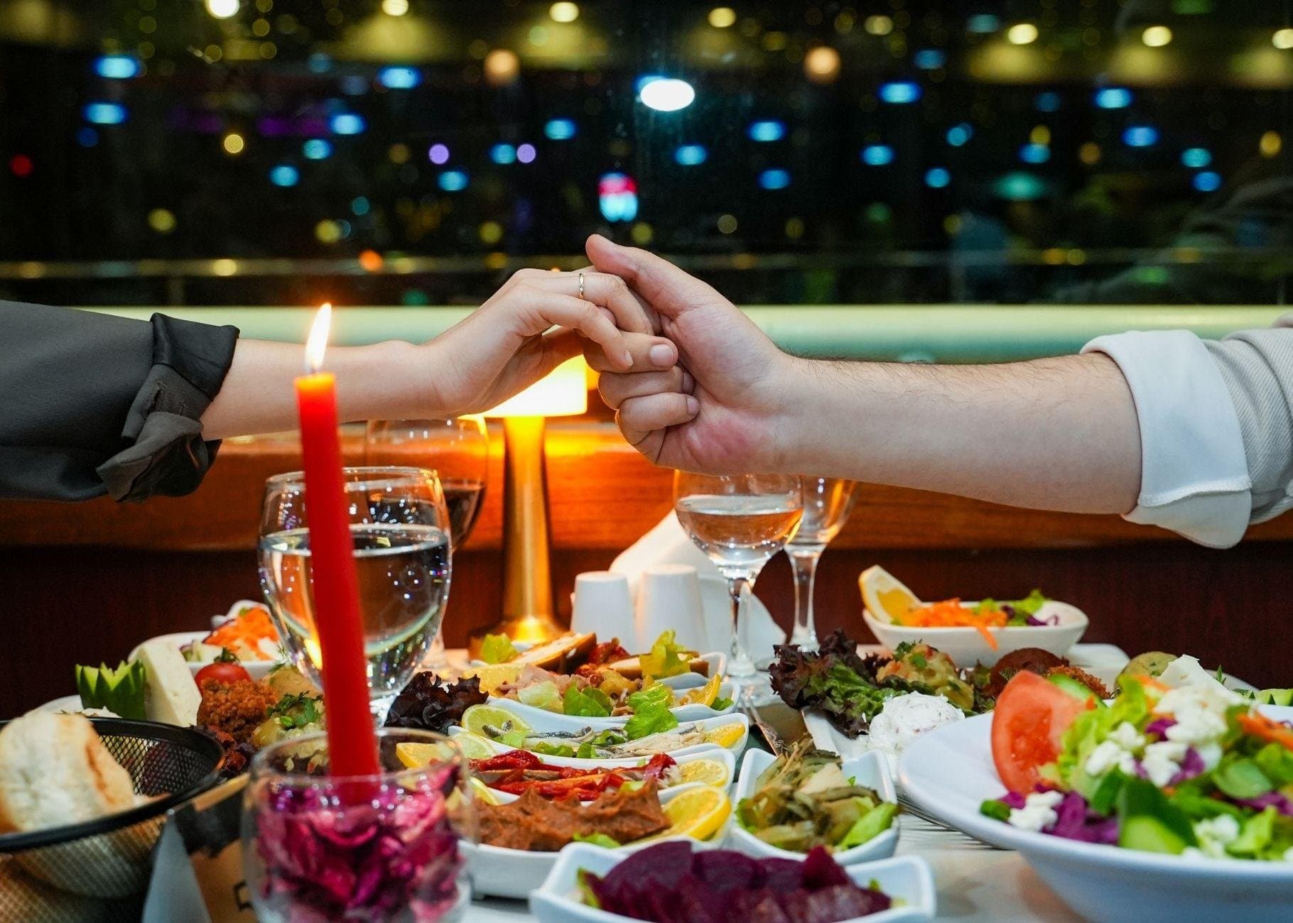 A candlelit dinner table set with Turkish mezes as the boat cruises the Bosphorus at night