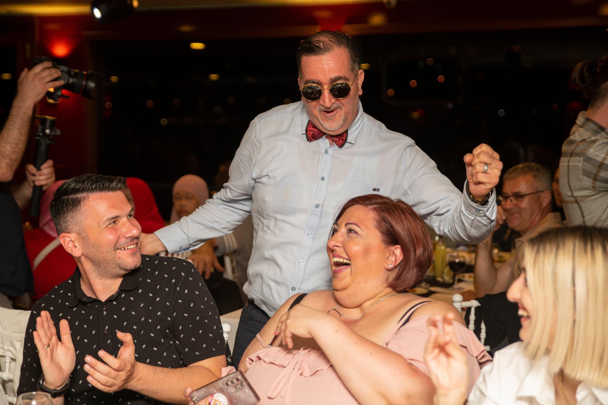 Guests laughing and celebrating at their table during the dinner cruise