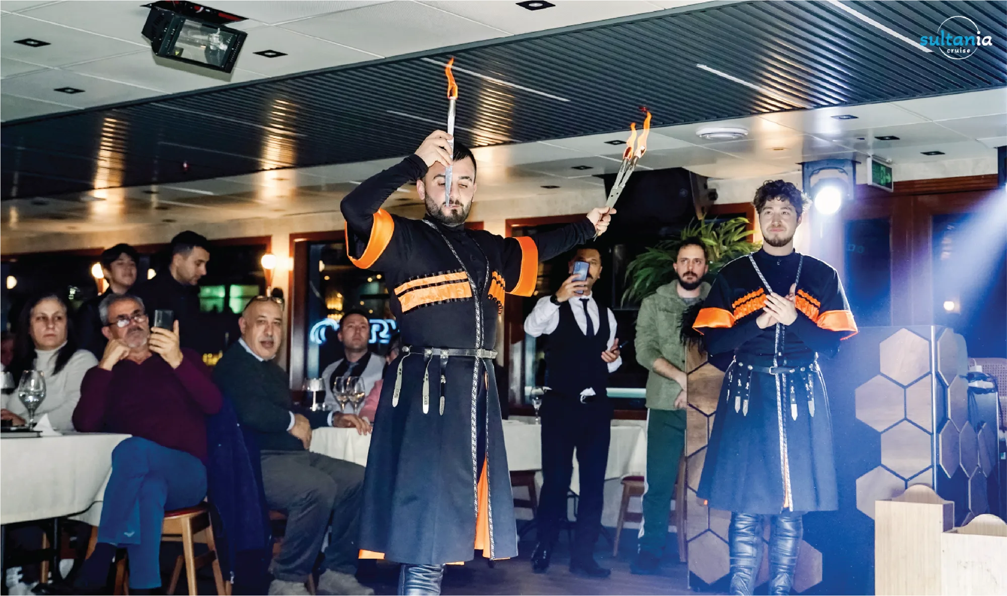Dancers performing a fire and knife show in folk costume on the boat