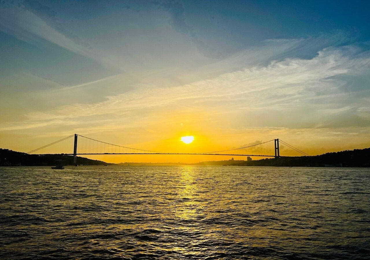 The sun setting over the Bosphorus Bridge seen from the water