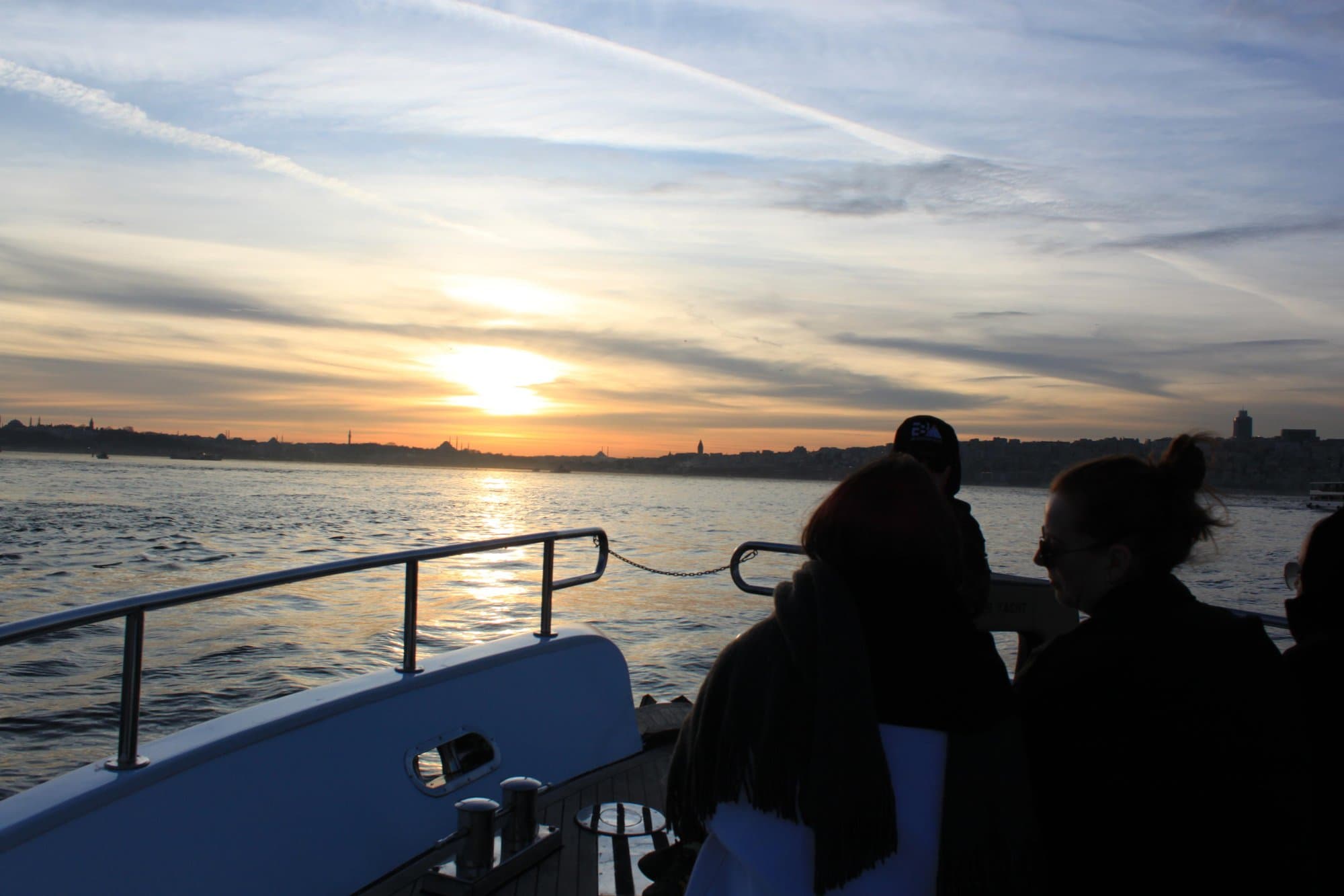 Guests on the yacht's bow watching the sunset over the Istanbul skyline