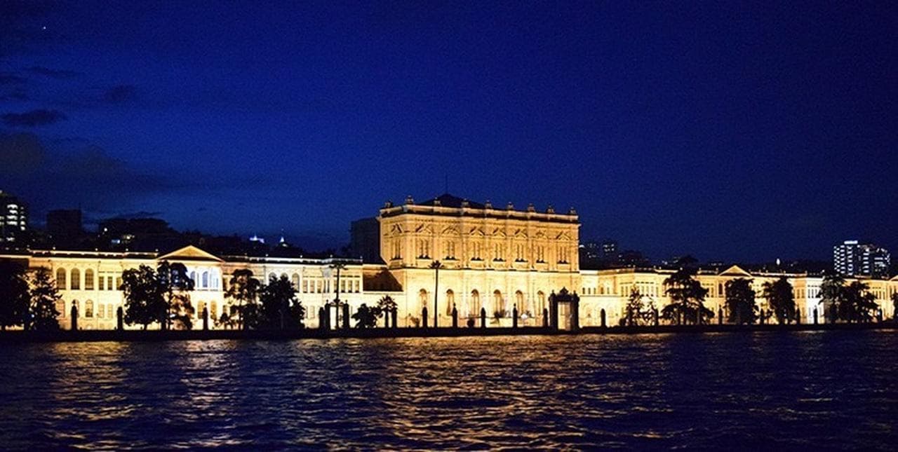 The Dolmabahçe Palace illuminated at night seen from the Bosphorus
