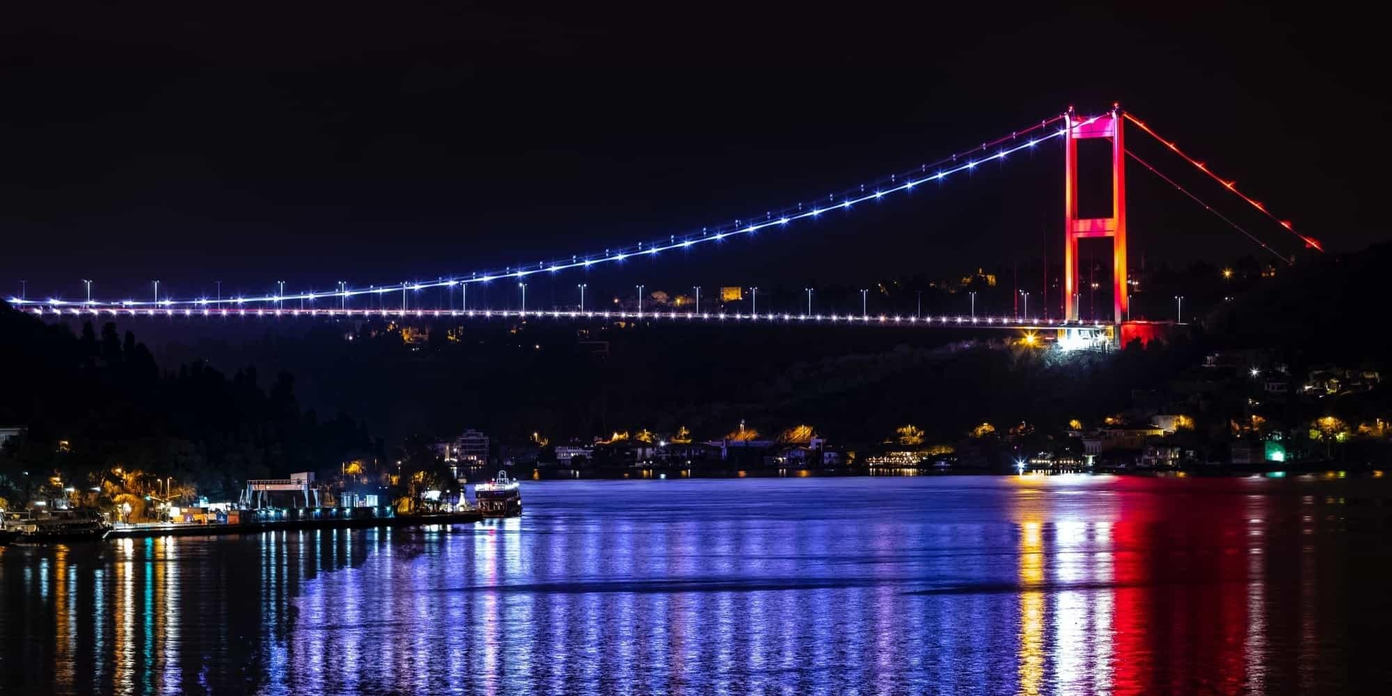 The Fatih Sultan Mehmet Bridge lit up over the Bosphorus at night