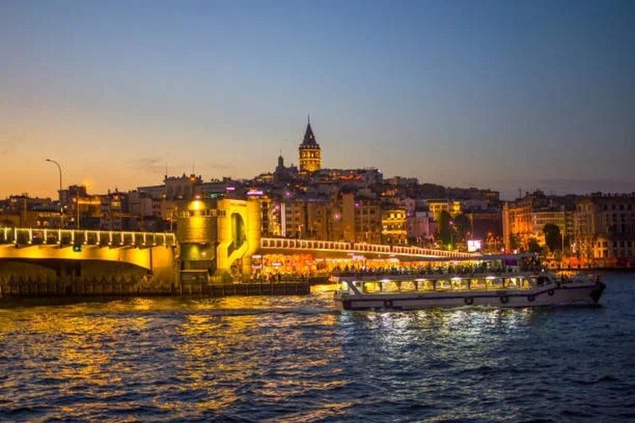 The Galata Tower and Galata Bridge at dusk over the water