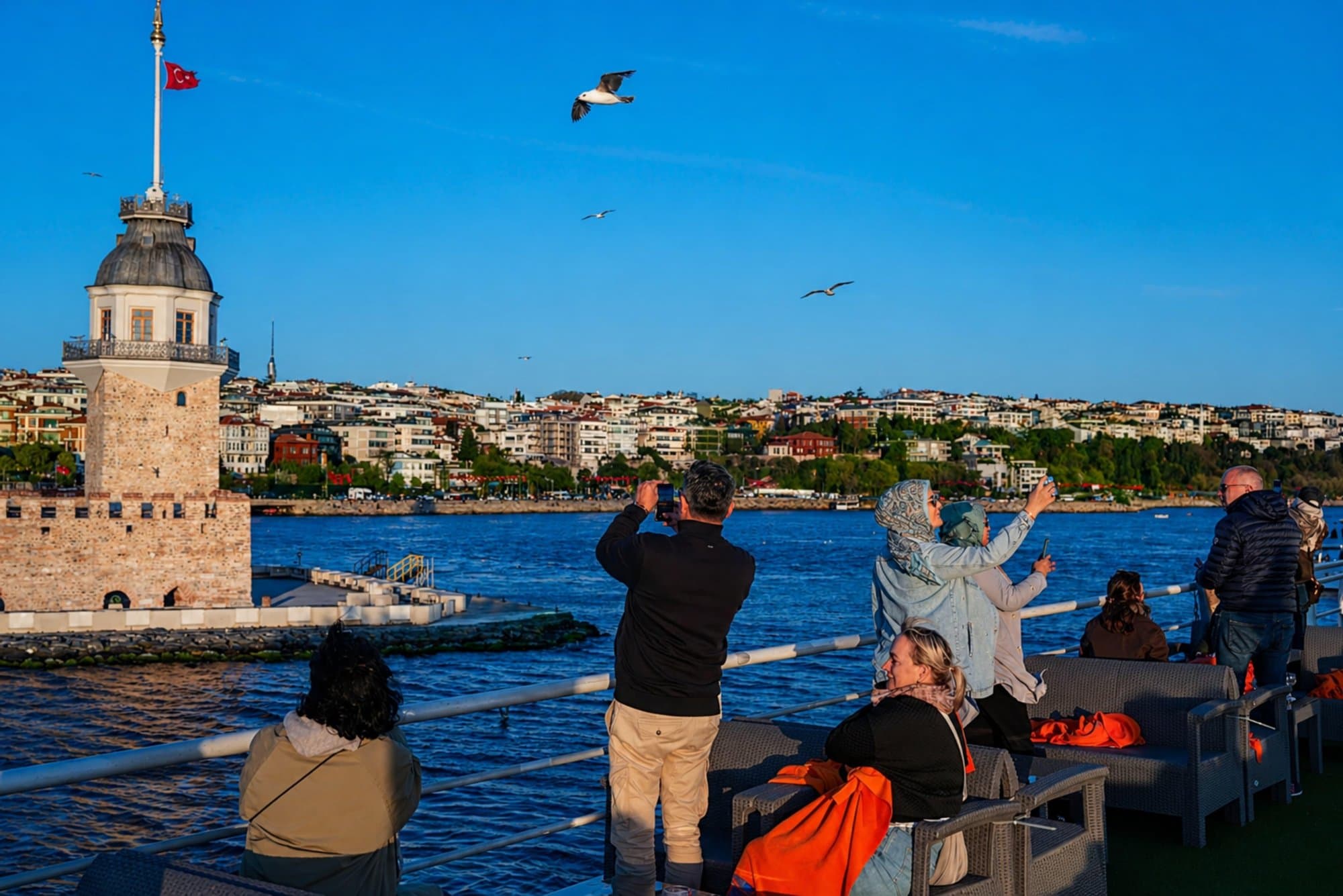Passengers on deck photographing the Maiden's Tower as the boat passes on the Bosphorus