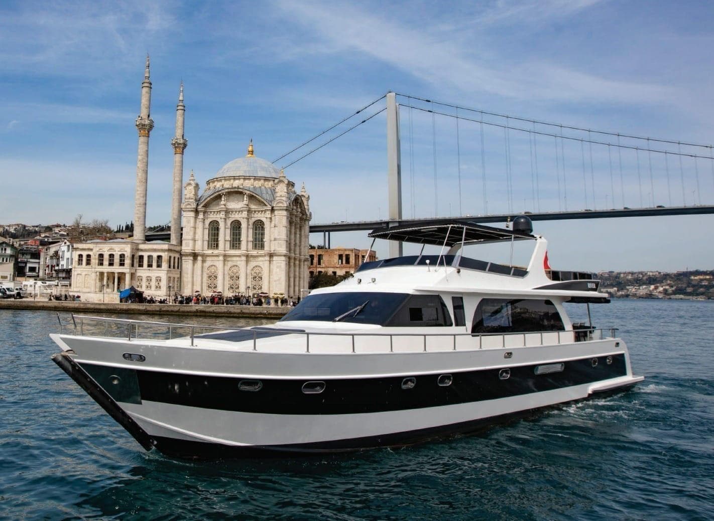 The cruise yacht passing the Ortaköy Mosque and the Bosphorus Bridge