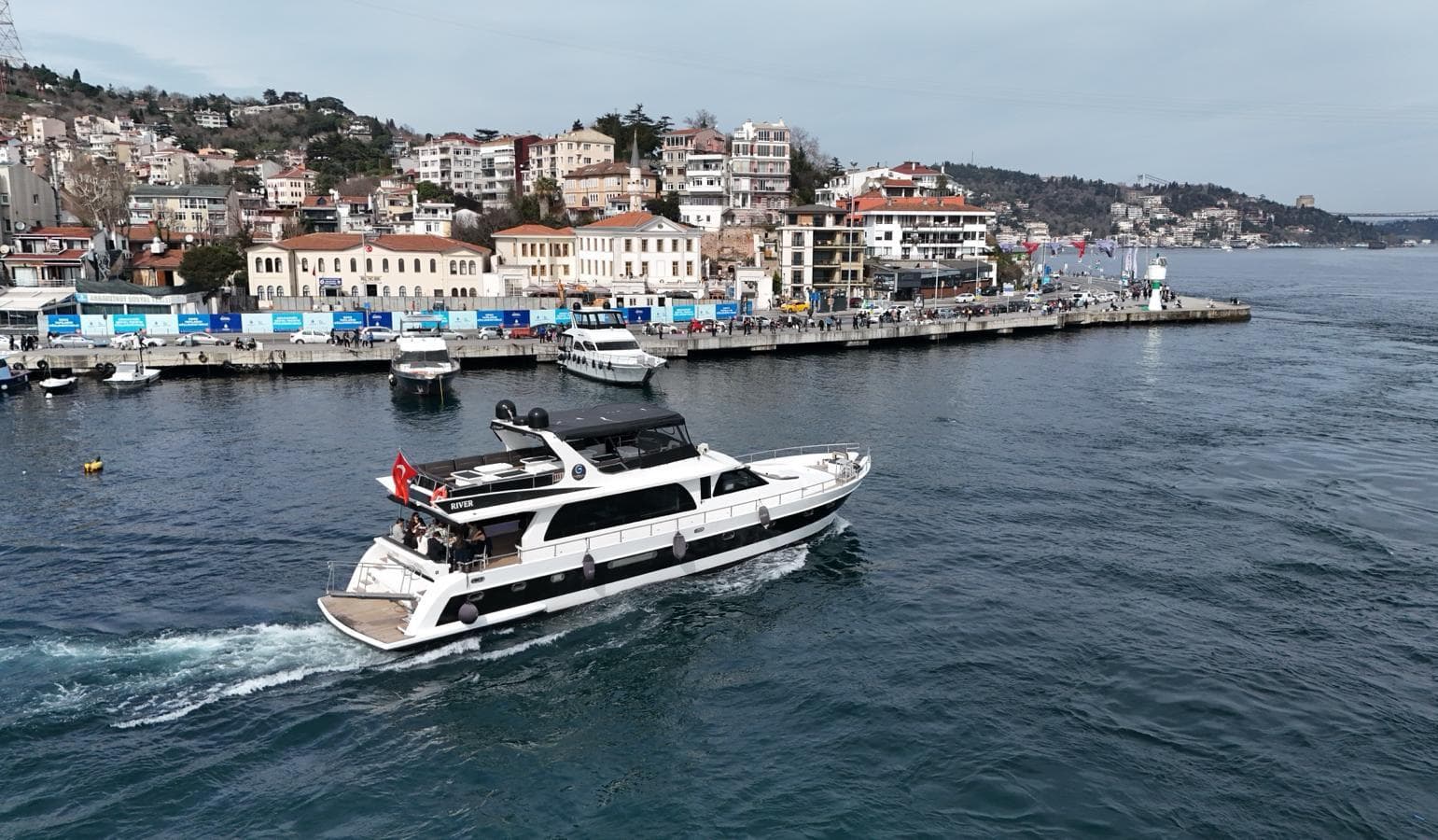 The cruise yacht sailing the Bosphorus close to the Istanbul shoreline