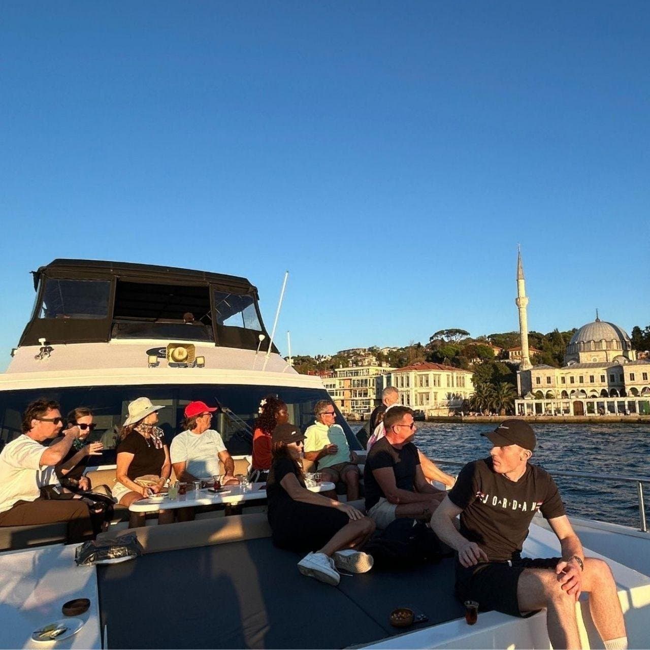 Guests on deck as the yacht passes a waterside mosque on the Bosphorus