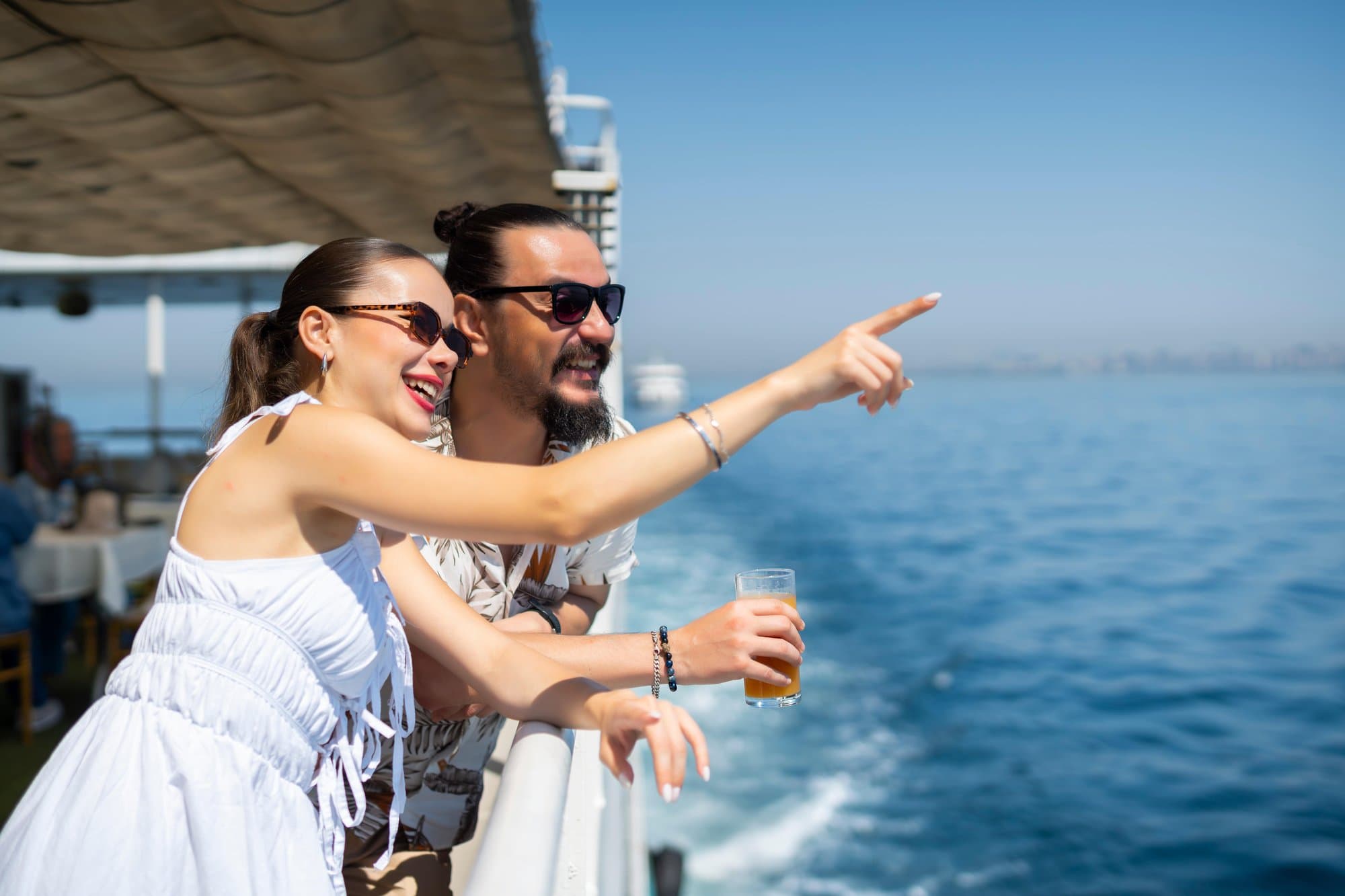 A couple on the sunny open deck looking out at the Bosphorus