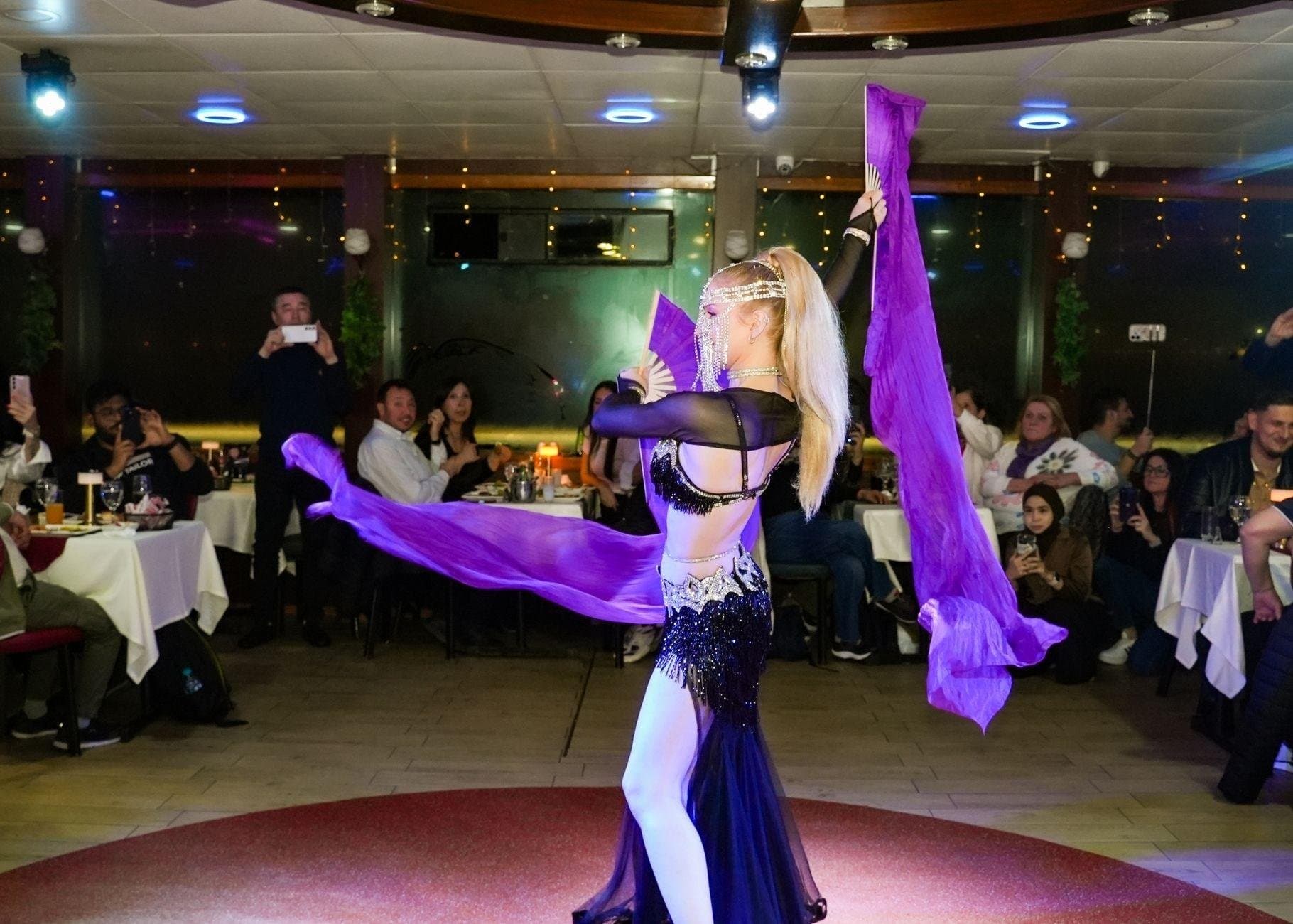 A belly dancer performing for diners on board